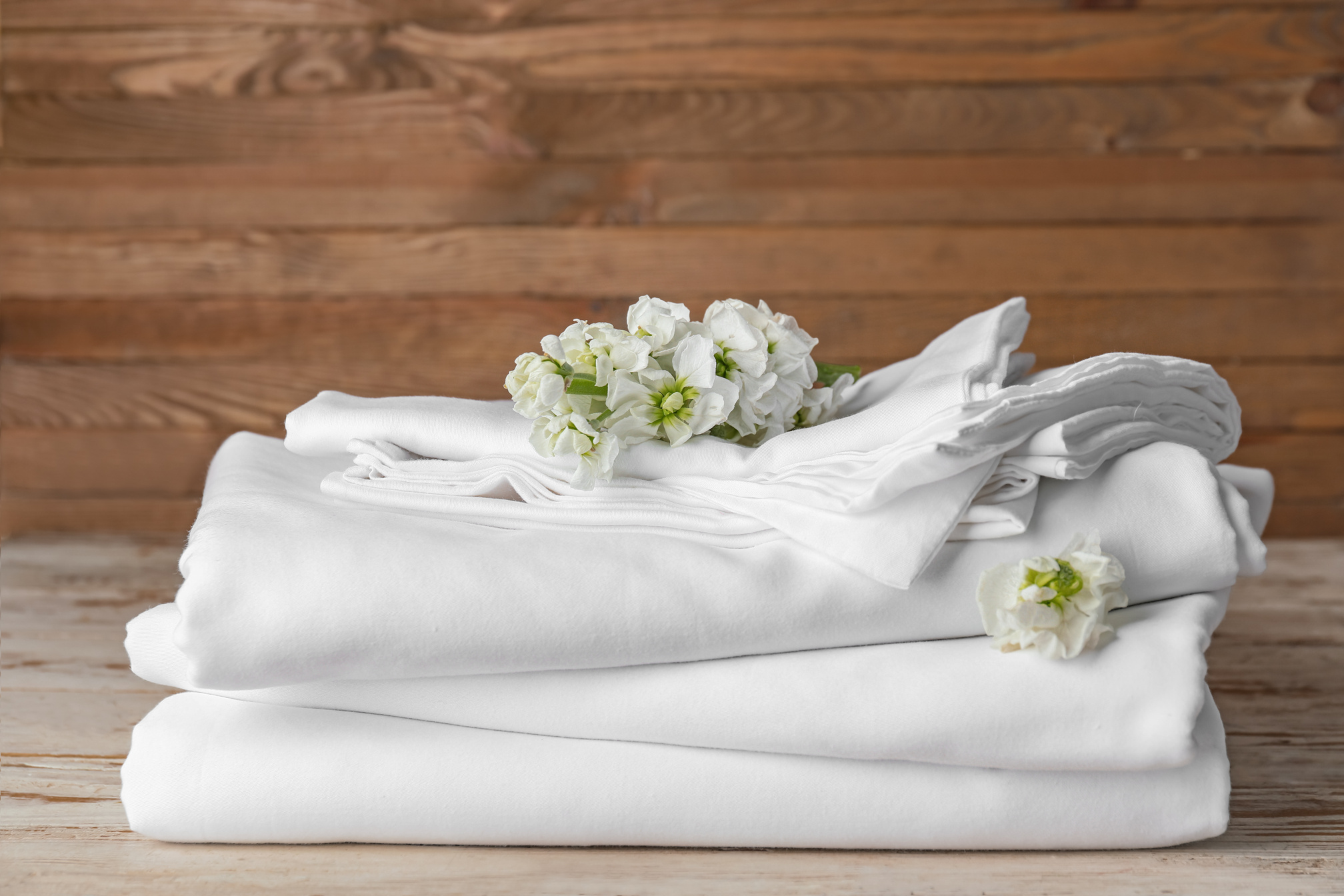 Stack of Clean Bed Sheets on Table